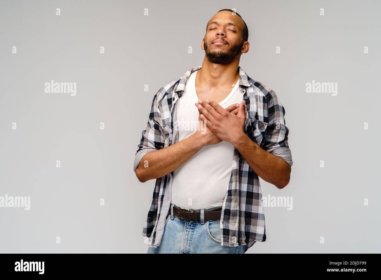heureux heureux homme afro-américain tenant les mains sur la poitrine à coeur sentiment amour appréciation gratitude honnêteté Banque D'Images