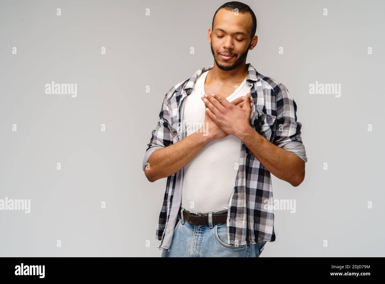 heureux heureux homme afro-américain tenant les mains sur la poitrine à coeur sentiment amour appréciation gratitude honnêteté Banque D'Images