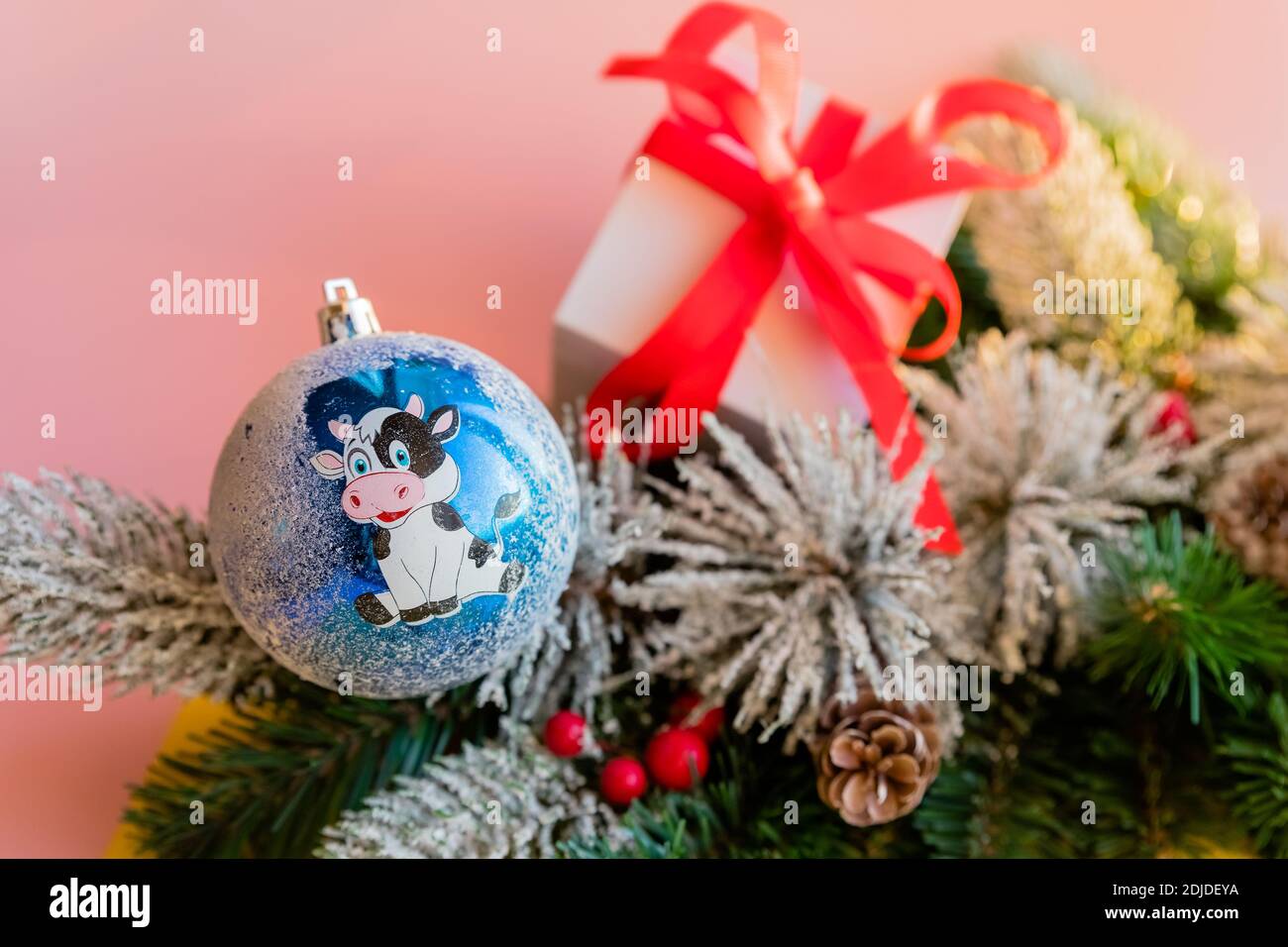 Décoration de Noël - une boule peinte à la main avec le symbole de l'année de l'Ox accroché à l'arbre de Noël. Banque D'Images