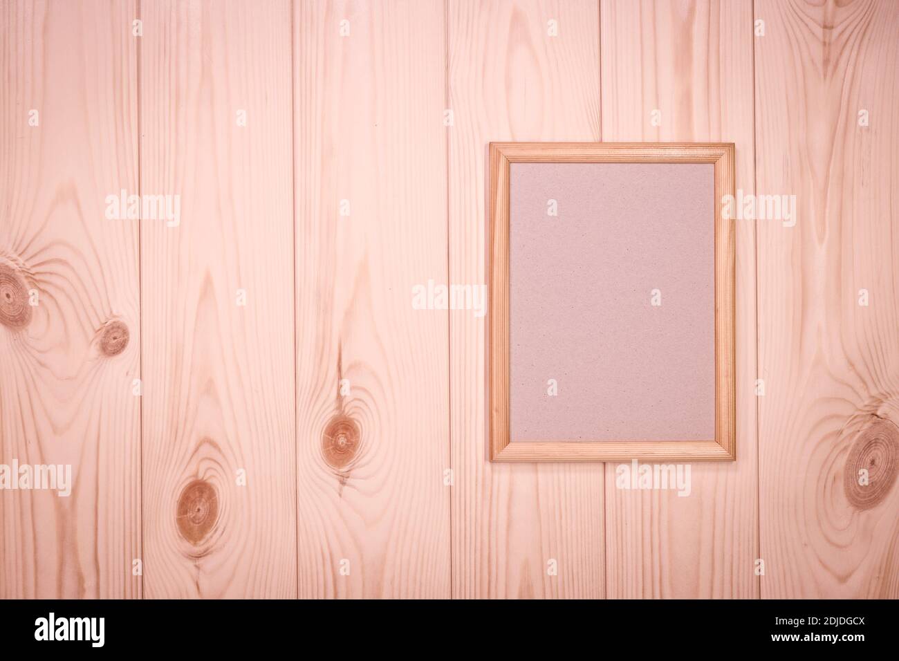 Maquette de cadre en bois vide sur fond de mur en bois de pin rose clair, montrer du texte ou du produit. Banque D'Images