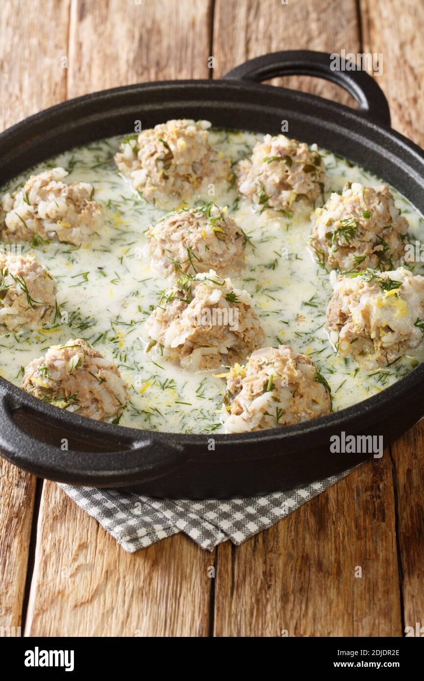 Yuvarlakia giouvarlakia est le boulette de viande de riz et de viande hachée servi en gros plan dans une assiette sur la table avec une sauce avgolemono. Verticale Banque D'Images