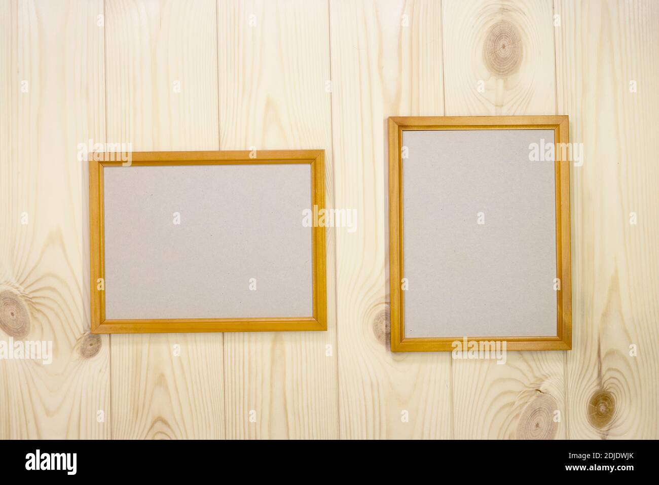 Faites une maquette de deux cadres en bois vides sur un arrière-plan mural en pin clair, montrez du texte ou du produit. Banque D'Images