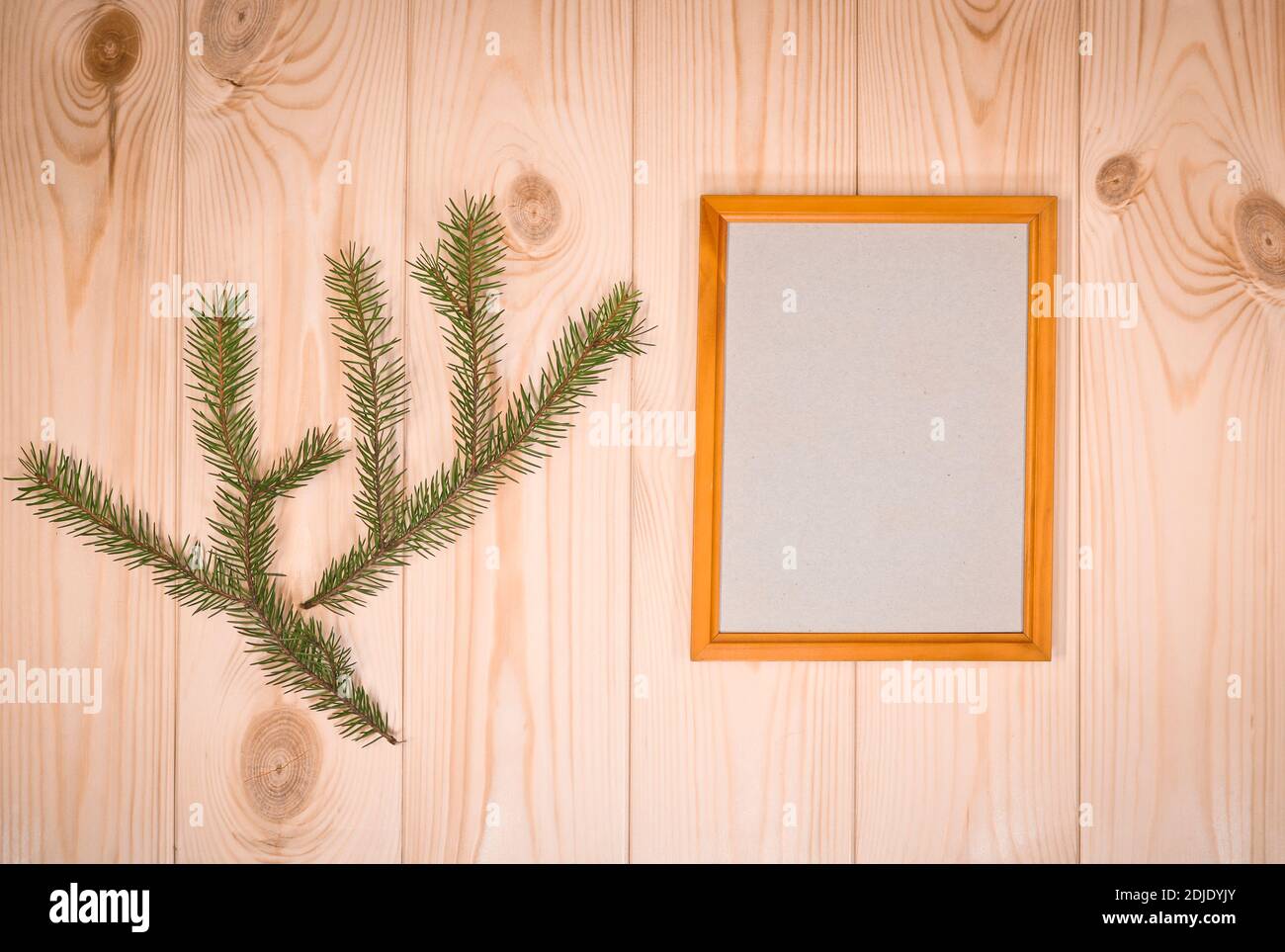 Faites une maquette des cadres en bois vides et des brindilles de sapin sur un arrière-plan mural en pin azur, montrez du texte ou du produit. Thème de Noël. Banque D'Images