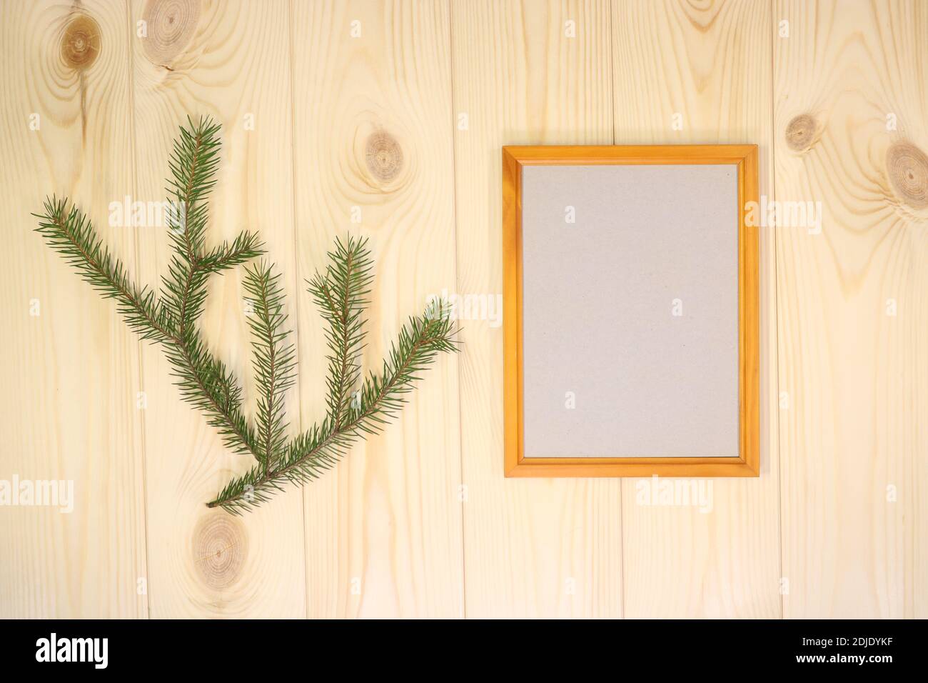 Faites une maquette des cadres en bois vides et des brindilles de sapin sur un arrière-plan mural en pin azur, montrez du texte ou du produit. Thème de Noël. Banque D'Images