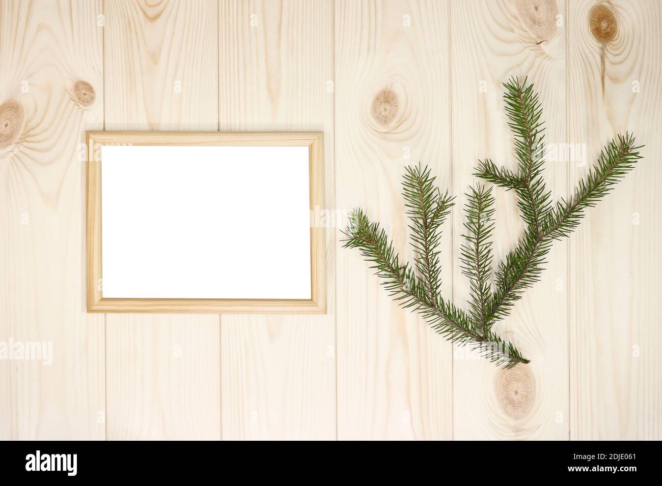 Faites une maquette des cadres en bois vides et des brindilles de sapin sur un arrière-plan mural en pin azur, montrez du texte ou du produit. Thème de Noël. Banque D'Images