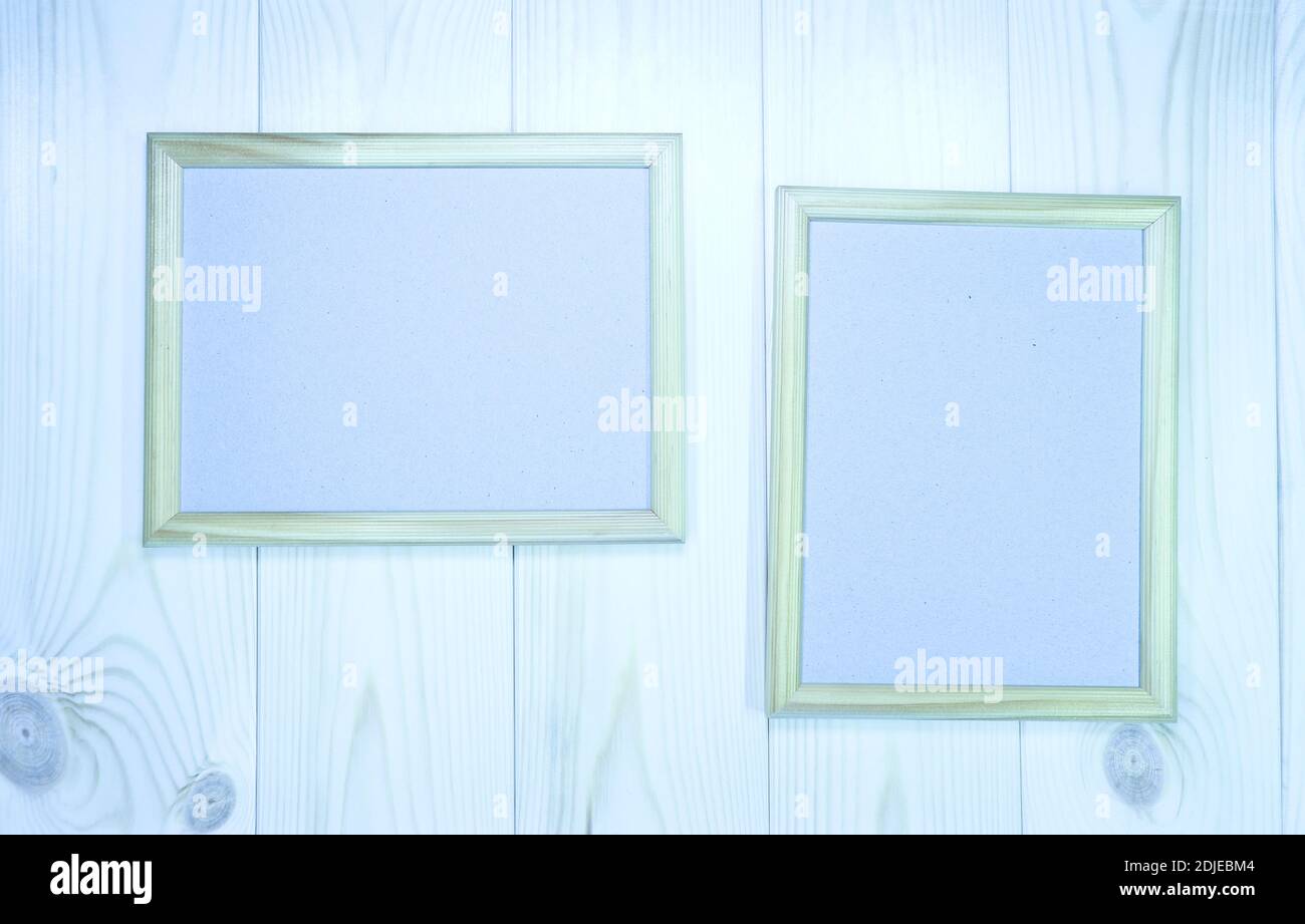 Faites une maquette de deux cadres en bois vides sur fond de mur en pin bleu clair, montrez du texte ou du produit. Banque D'Images