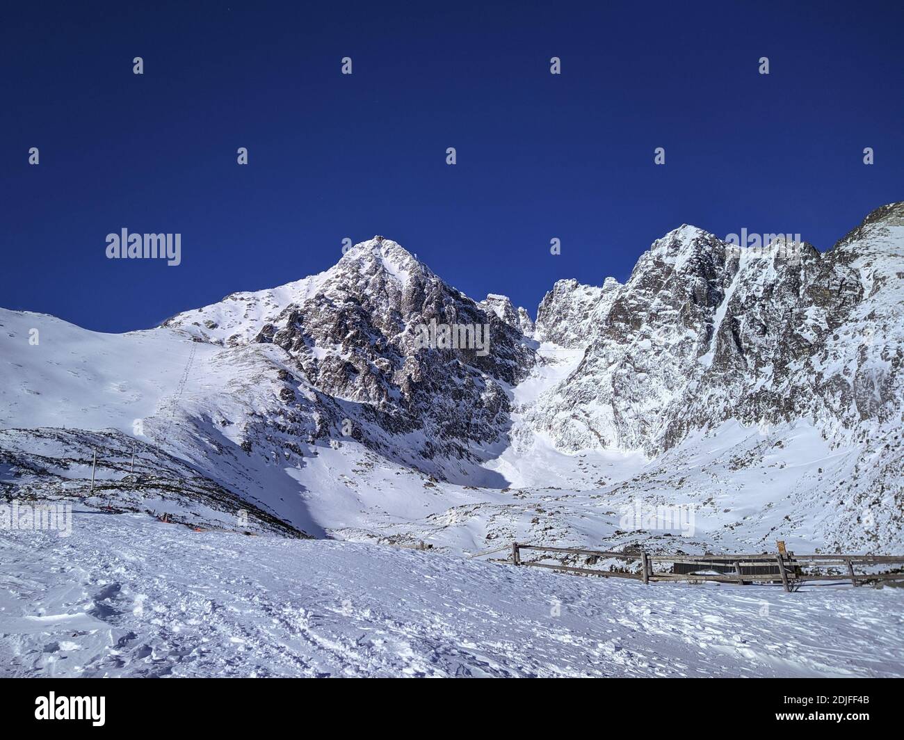 Montagnes aux sommets enneigés contre Ciel Bleu clair Banque D'Images