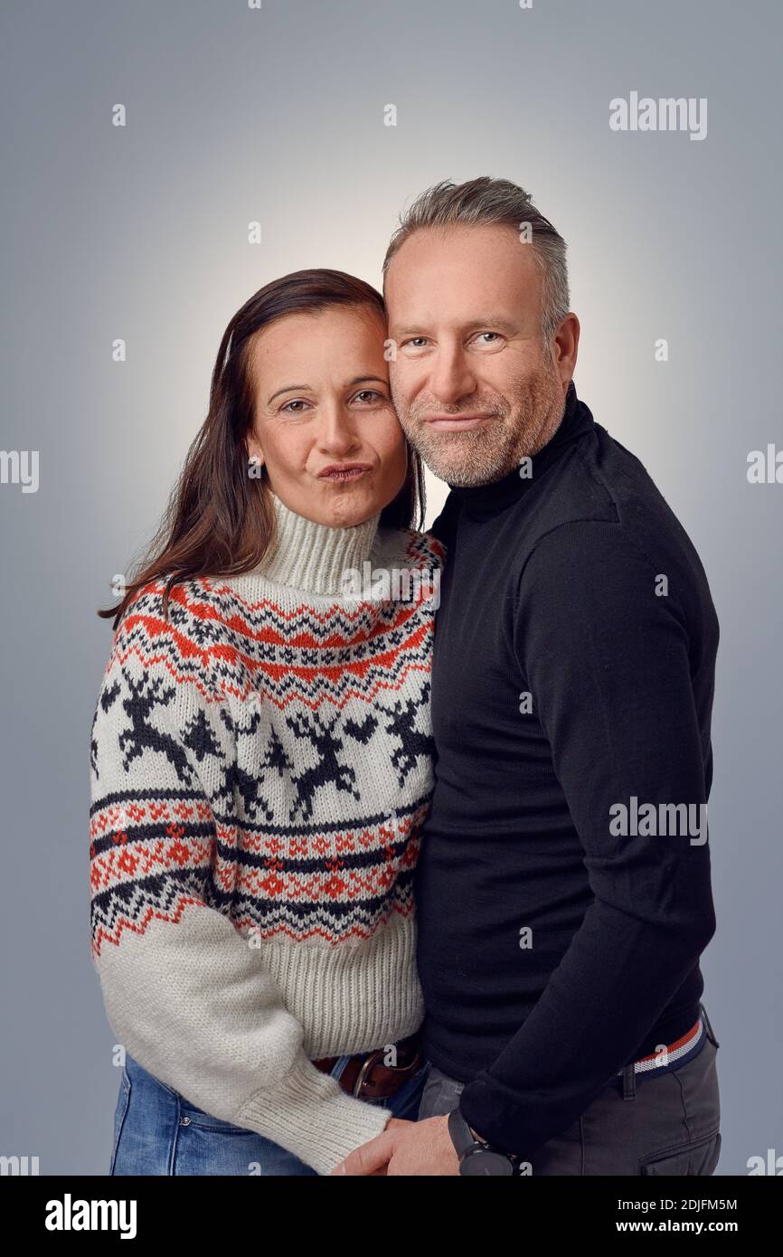 Couple heureux d'âge moyen qui rit et se embrasse en portant un chapeau de père noël et serre-tête en elk Banque D'Images