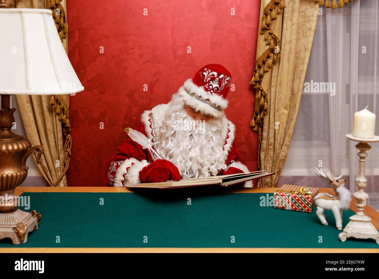 Le Père Noël écrit sur le livre assis à la table. CopySpace. Banque D'Images Le Père Noël écrit sur le livre assis à la table. CopySpace. Banque D'Images