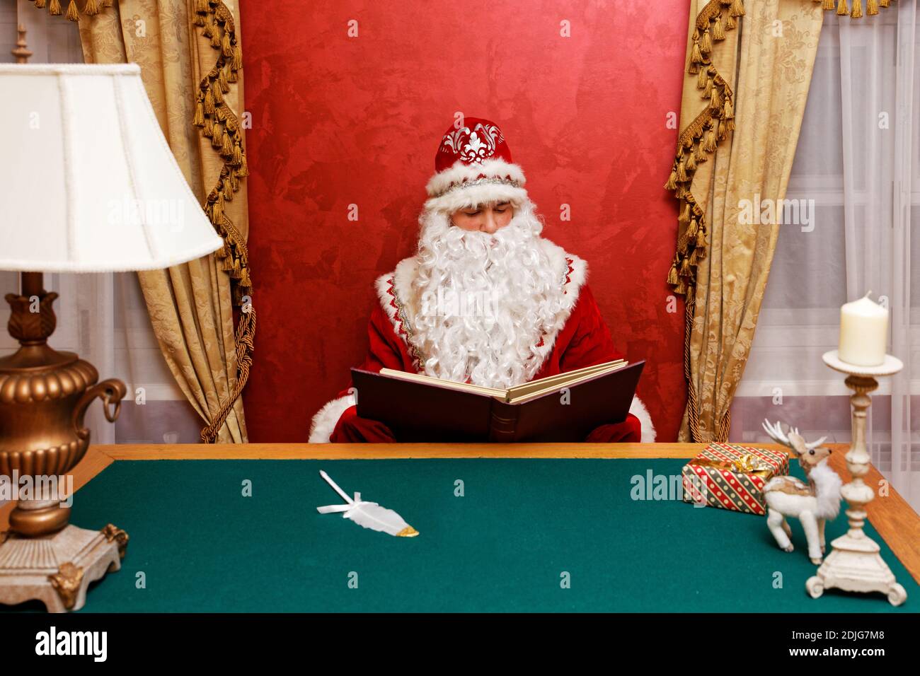 Le Père Noël a lu un livre assis à la table. CopySpace. Banque D'Images Le Père Noël a lu un livre assis à la table. CopySpace. Banque D'Images