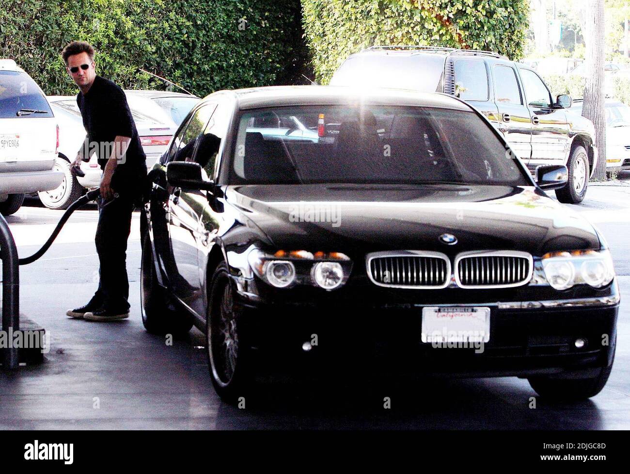 Exclusif !! Matthew Perry mutli tâches à Beverly Hills, ca. L'acteur a bavardé sur son téléphone portable tout en remplissant son réservoir de gaz et en se tenant à une bouteille de la boisson énergétique, Diet Red Bull 03/02/06 Banque D'Images
