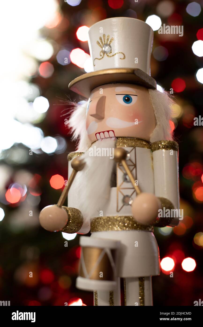 Statuette nutcracker du batteur soldat classique avec uniforme blanc et or et le tambour vu du côté devant un Arbre de Noël Banque D'Images