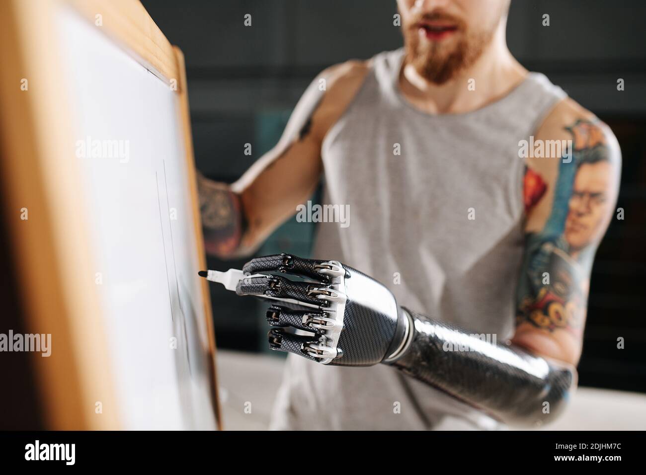 Image d'un homme de cyborg avec une main bionique sur laquelle écrire une carte avec marqueur permanent Banque D'Images