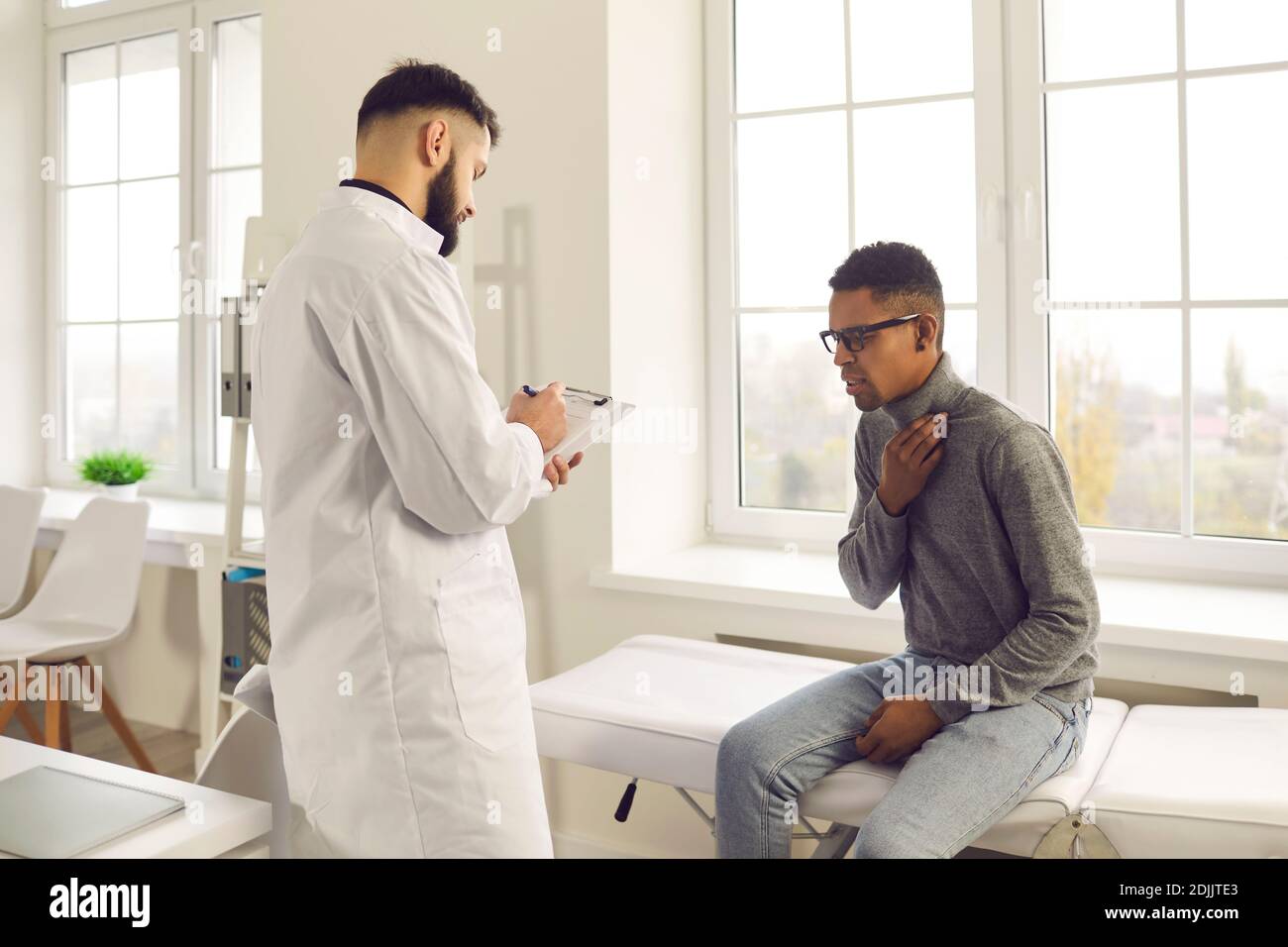 Un jeune patient informe le médecin de son mal de gorge et de sa toux pendant la visite à l'hôpital Banque D'Images