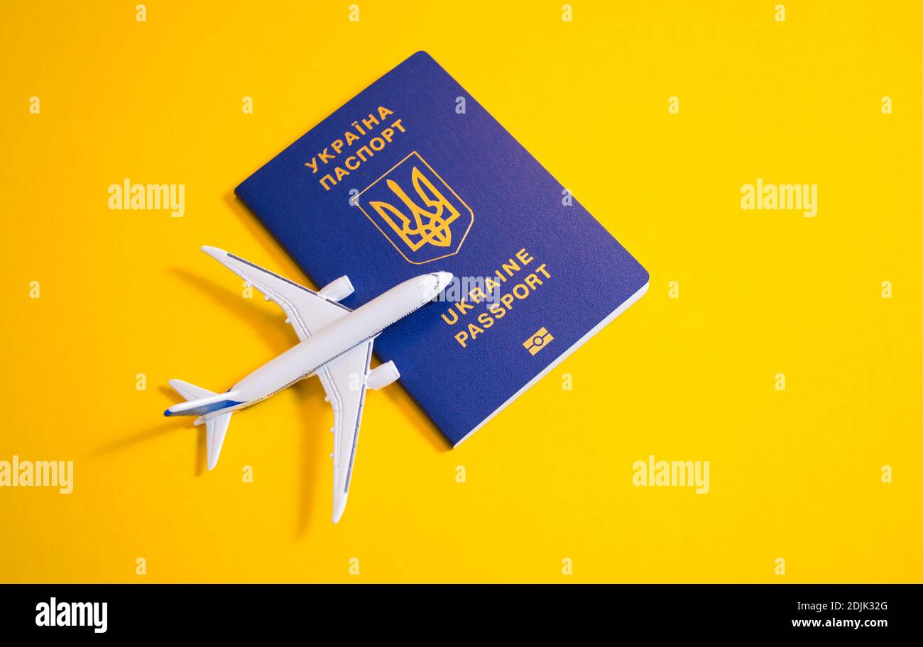 Kiev, Ukraine - 25 novembre 2020: Gros plan passeport biométrique ukrainien avec avion jouet à proximité Banque D'Images