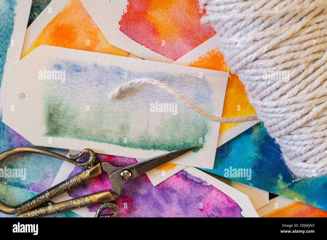 Étiquettes cadeau faites maison en papier aquarelle et peintes avec de la peinture aquarelle dans des motifs abstraits à écoulement libre. Banque D'Images