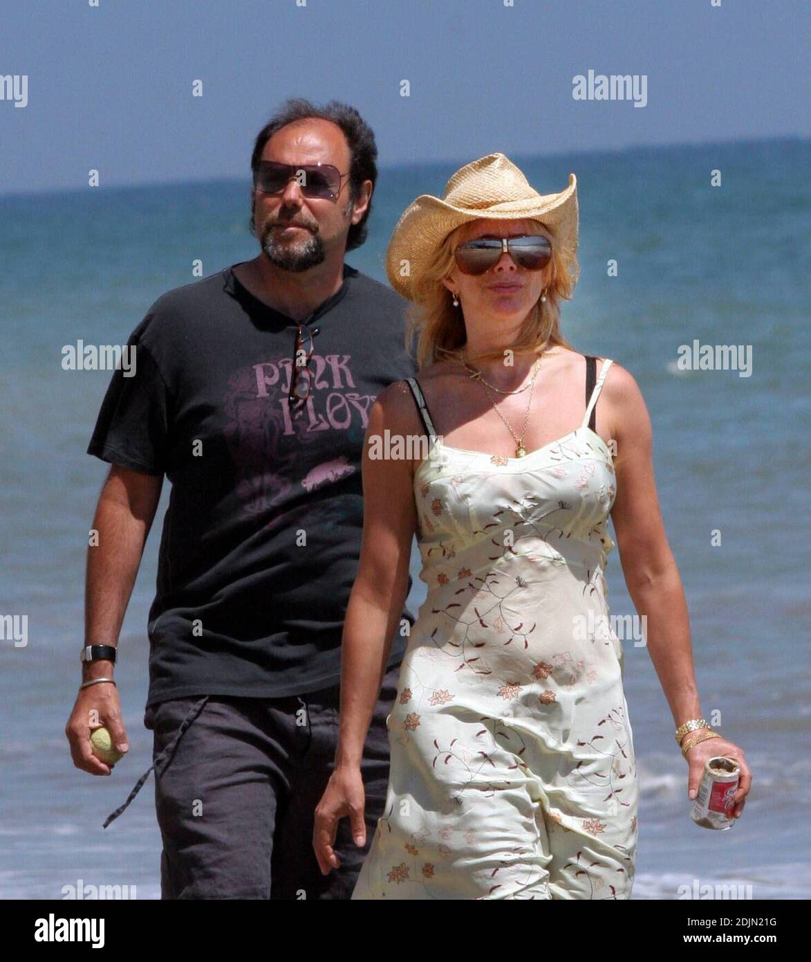 Rosanna Arquette fait une promenade sur la plage avec un ami tout en jouant à FETCH avec quelques chiens. Peut-être l'actrice est-elle consciente de la portée, car elle semble être en fourre-tout un pot de yogourt rempli de sable. Malibu, Calif. 7/9/06 Banque D'Images