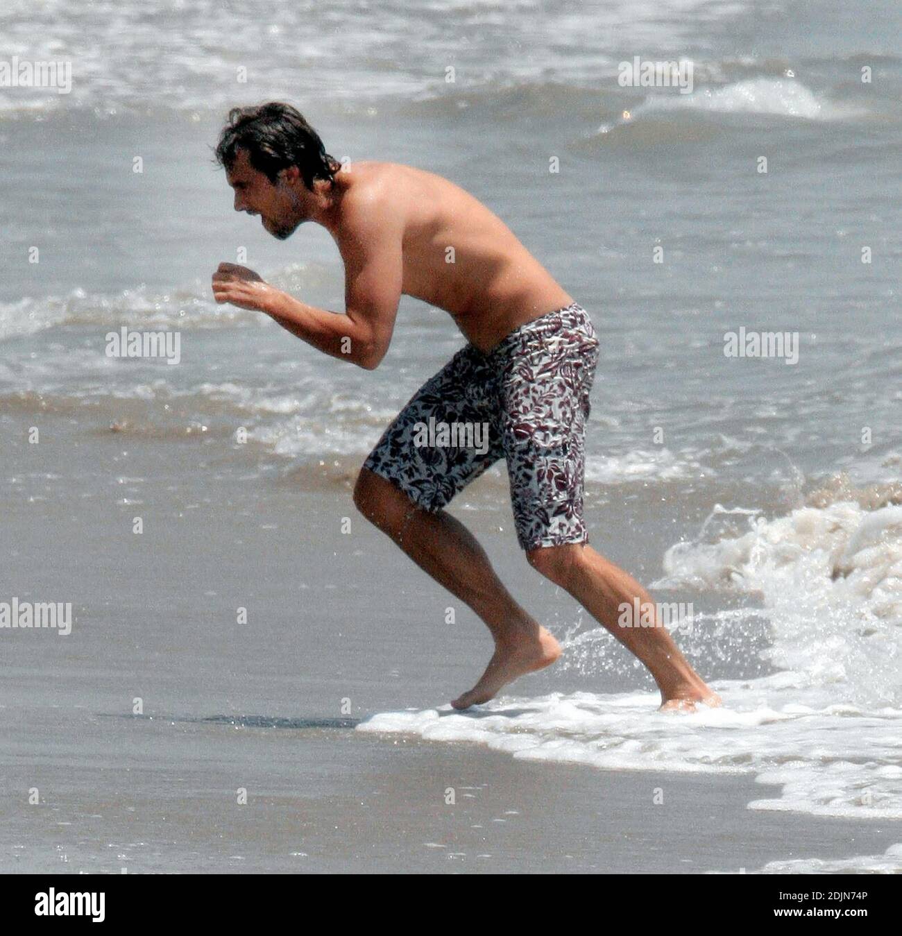 Exclusif !! Stuart Townsend joue avec un de ses chiens à l'extérieur de sa maison de plage Malibu en Californie. 7/22/06 [[rac]] Banque D'Images