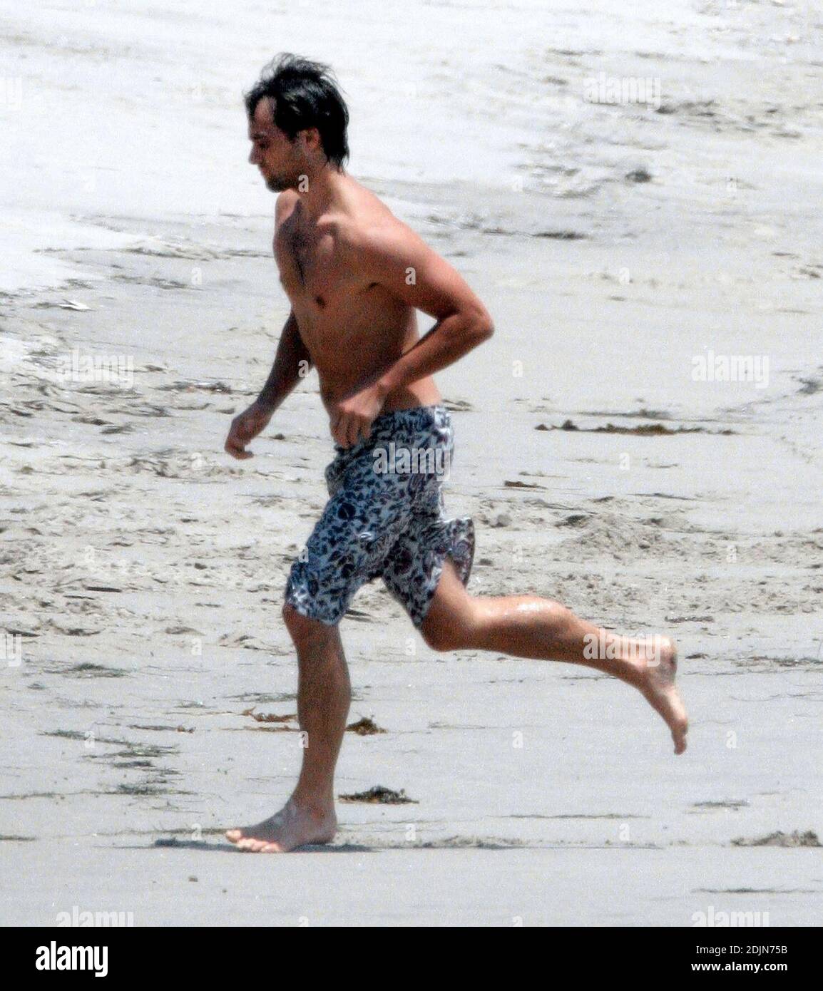 Exclusif !! Stuart Townsend joue avec un de ses chiens à l'extérieur de sa maison de plage Malibu en Californie. 7/22/06 [[rac]] Banque D'Images