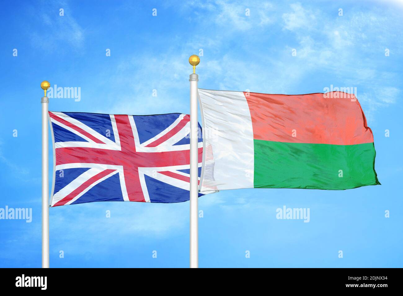 Royaume-Uni et Madagascar deux drapeaux sur les mâts et le bleu ciel nuageux Banque D'Images