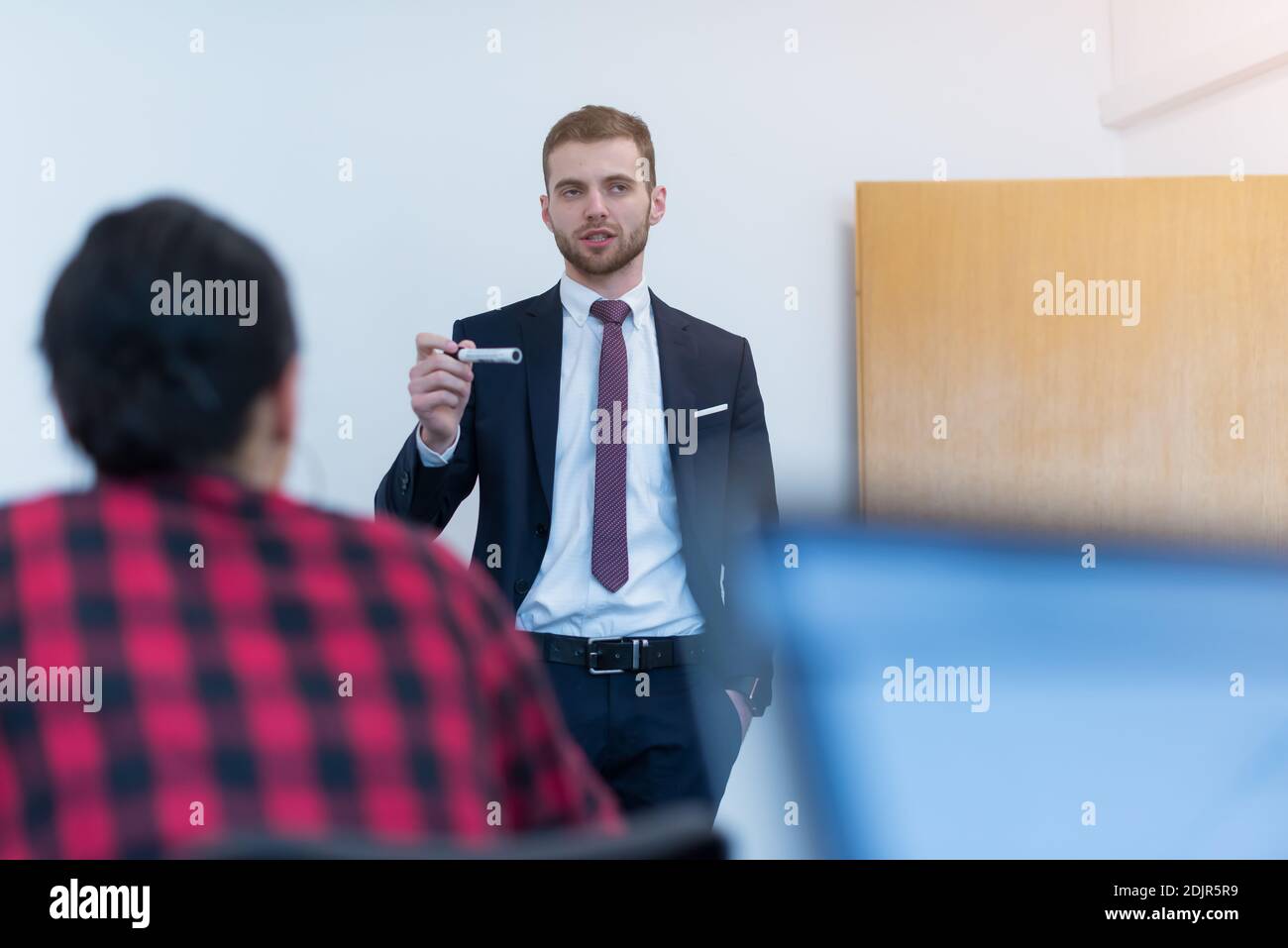 Jeunes collègues modernes ayant une présentation sur les nouvelles stratégies marketing sur le tableau blanc Banque D'Images