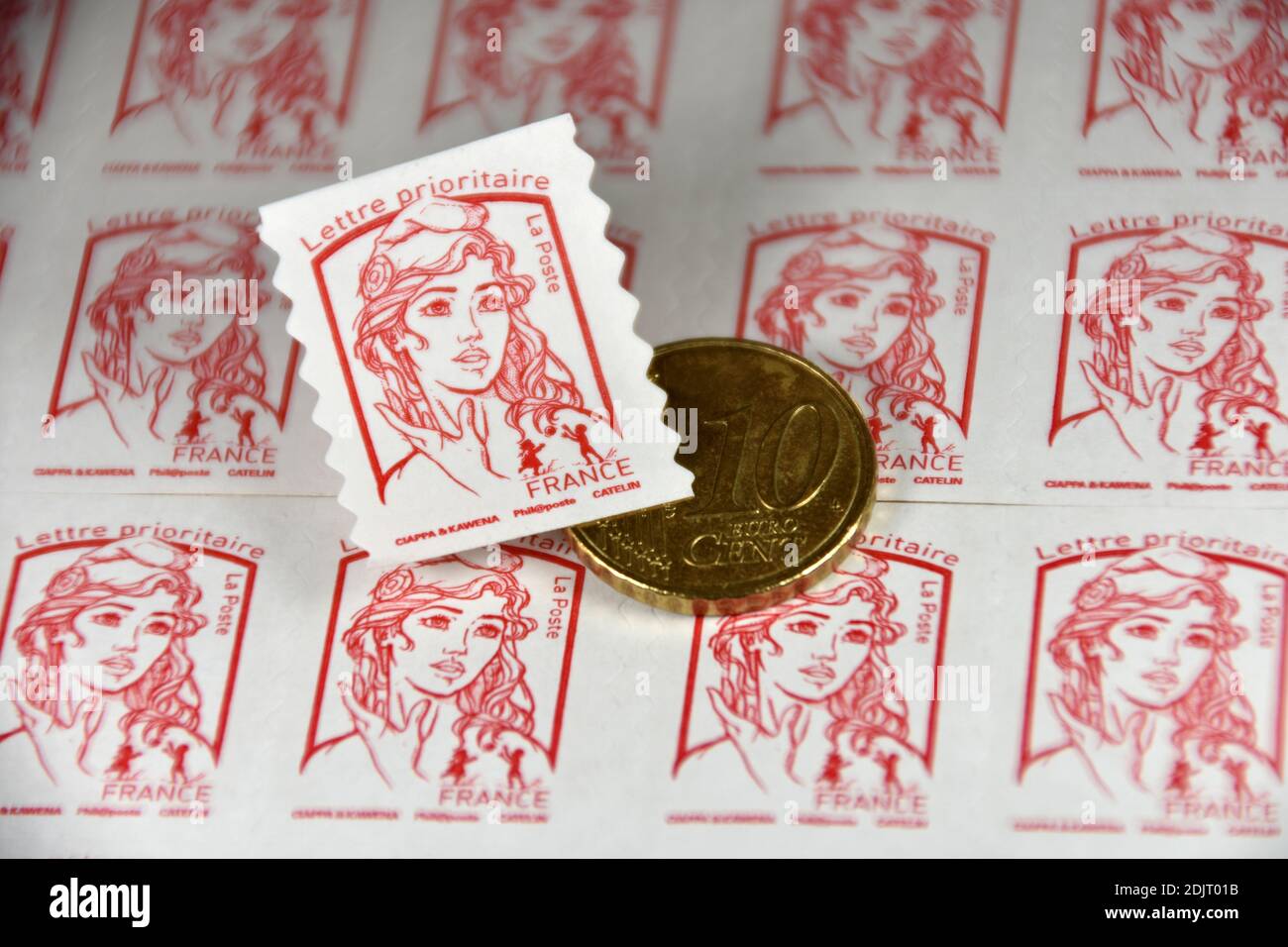 Sur cette photo, un cachet de poste et une pièce de 10 centimes d'euro sont exposés. Le groupe la poste a annoncé que le prix des timbres augmentera en moyenne de 4.7% à compter du 1er janvier 2021. Banque D'Images