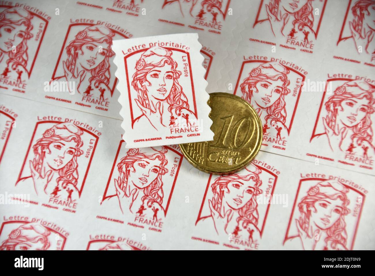 Sur cette photo, un cachet de poste et une pièce de 10 centimes d'euro sont exposés. Le groupe la poste a annoncé que le prix des timbres augmentera en moyenne de 4.7% à compter du 1er janvier 2021. Banque D'Images