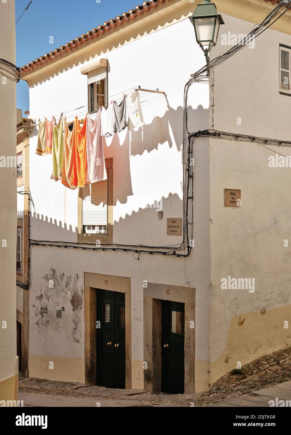 Des clotes pendent sur la rue en pierre de galets de Castelo de vide Banque D'Images