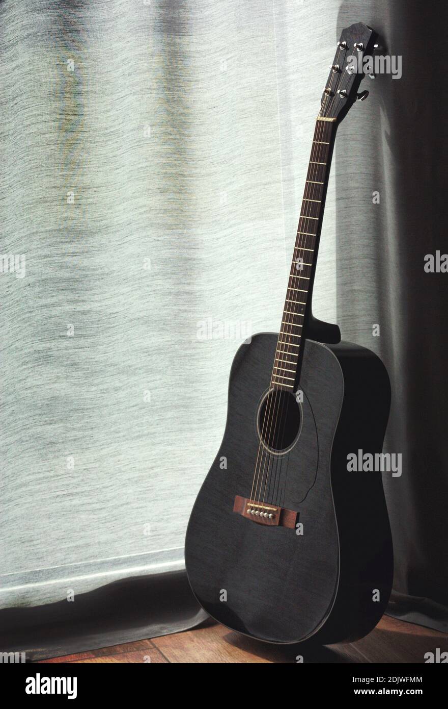 Guitare contre rideau de fenêtre Photo Stock - Alamy