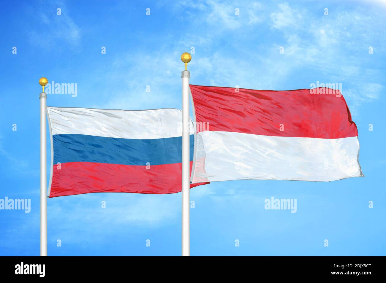Russie et Indonésie deux drapeaux sur les mâts et bleu nuageux ciel Banque D'Images