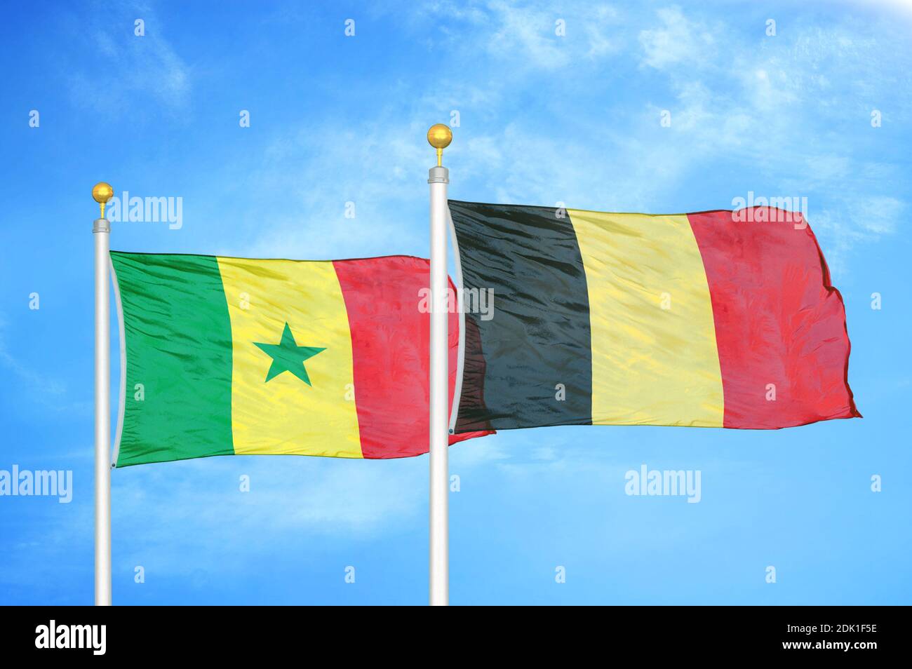 Sénégal et Belgique deux drapeaux sur les mâts de drapeaux et bleu nuageux ciel Banque D'Images
