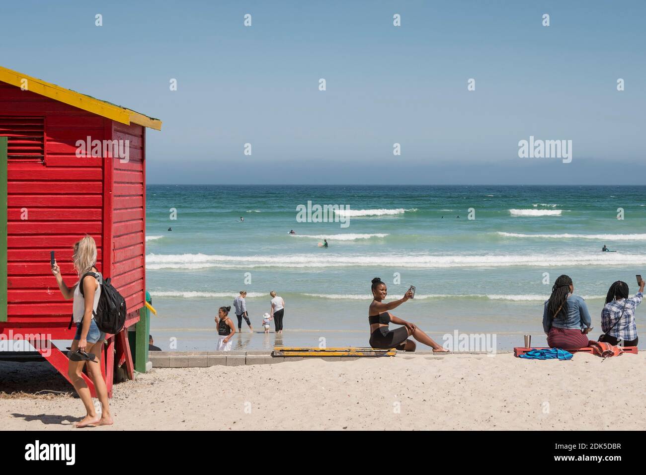 Des femmes sur leur téléphone portable, prenant des selfies, à Surferss' Corner, Muizenberg Beach, Muizenberg, False Bay, Cape Town, Afrique du Sud. Banque D'Images