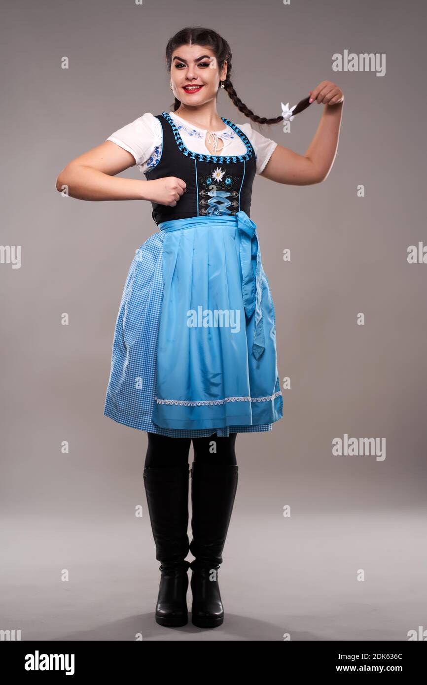 Jeune femme en costume traditionnel de folklore allemand, isolée sur fond  gris Photo Stock - Alamy