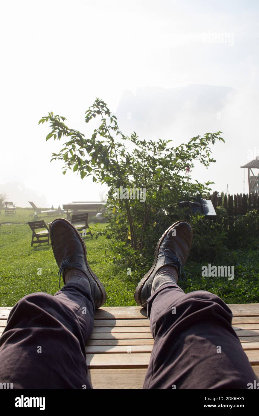 Pieds surélevés avec des chaussures dans le jardin Banque D'Images