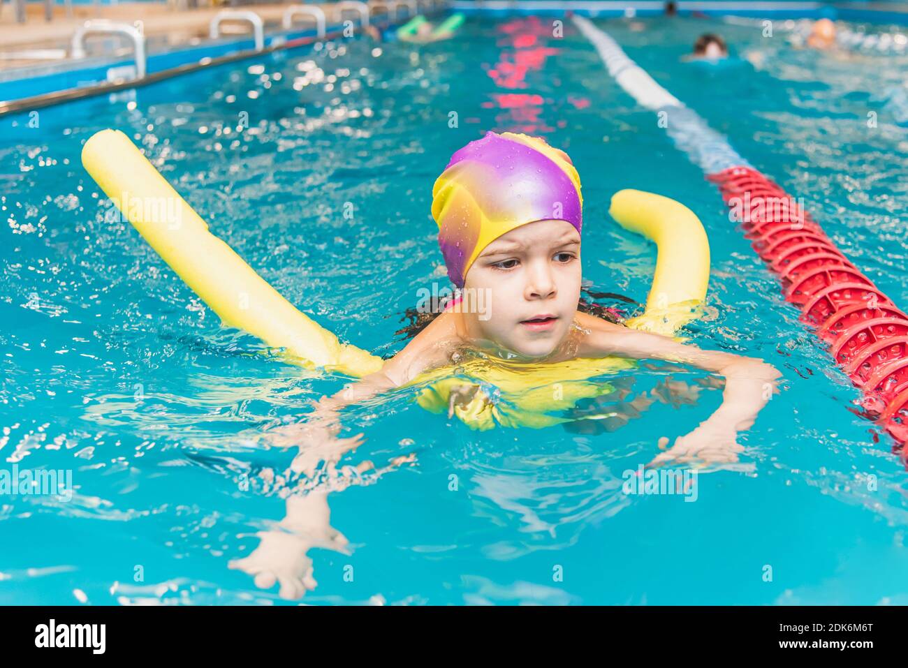 Un petit garçon avec un gilet de sauvetage sur sa poitrine apprend à nager  dans une piscine intérieure Photo Stock - Alamy