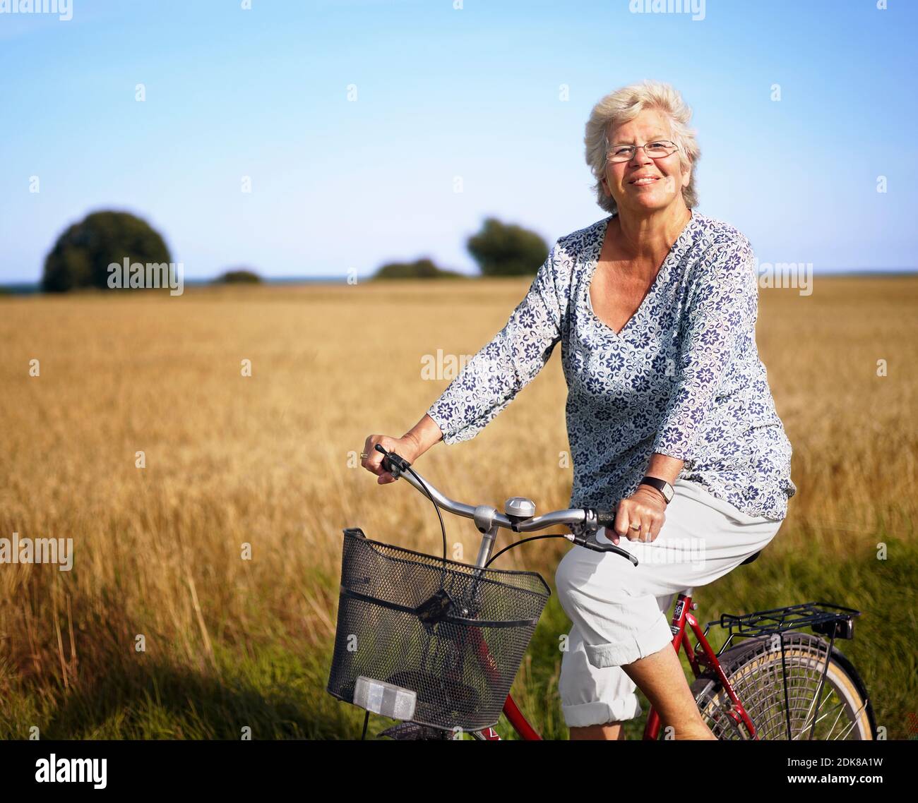 Femme plus âgée en vélo et souriant Banque D'Images