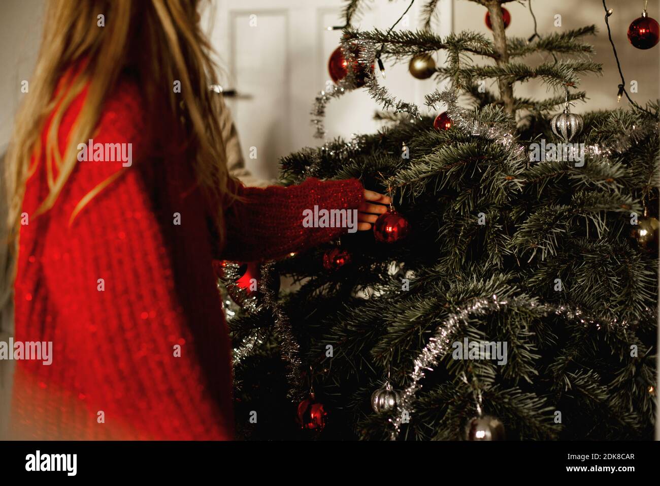 Girl decorating Christmas Tree Banque D'Images