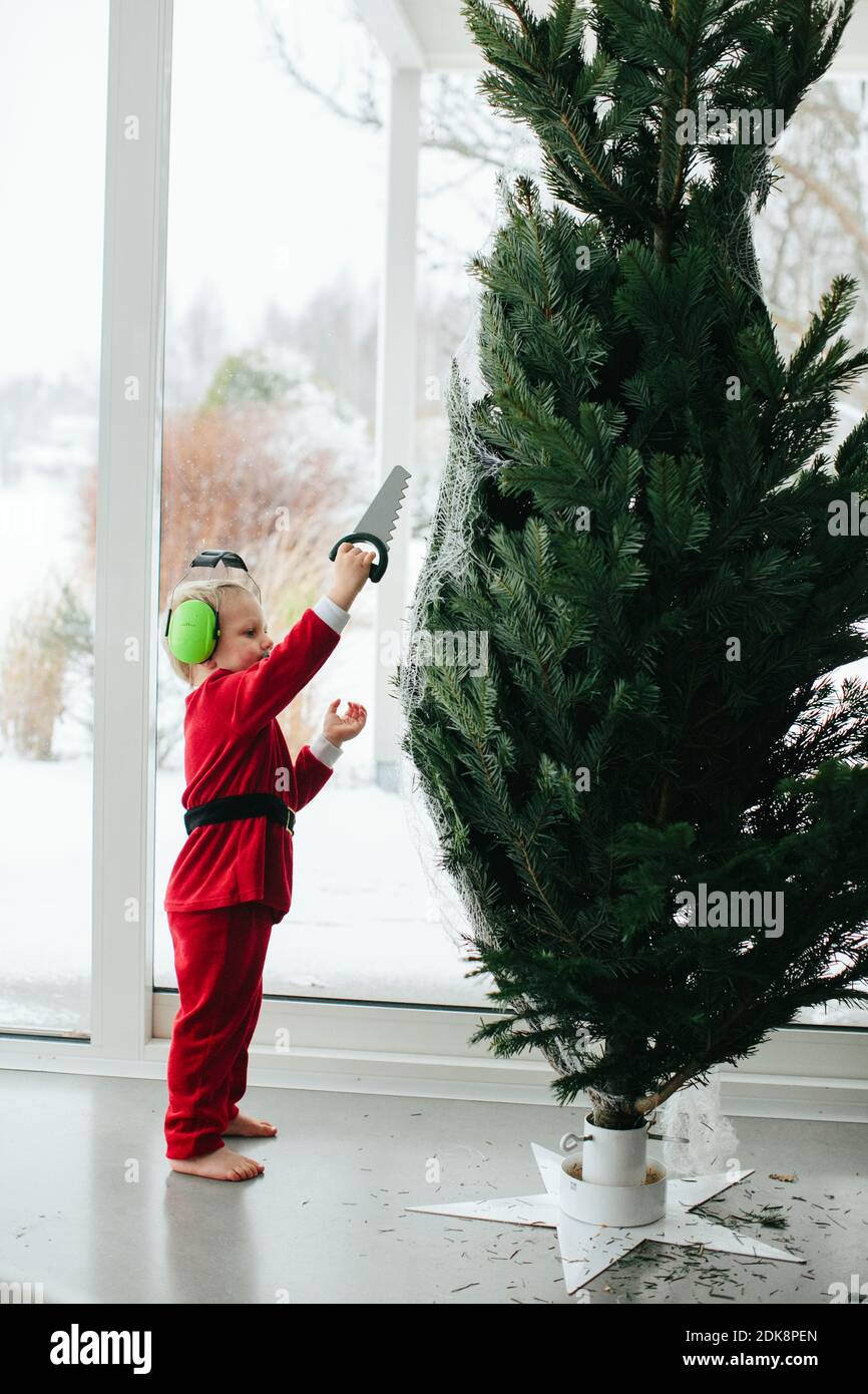 Garçon debout près de l'arbre de Noël Banque D'Images