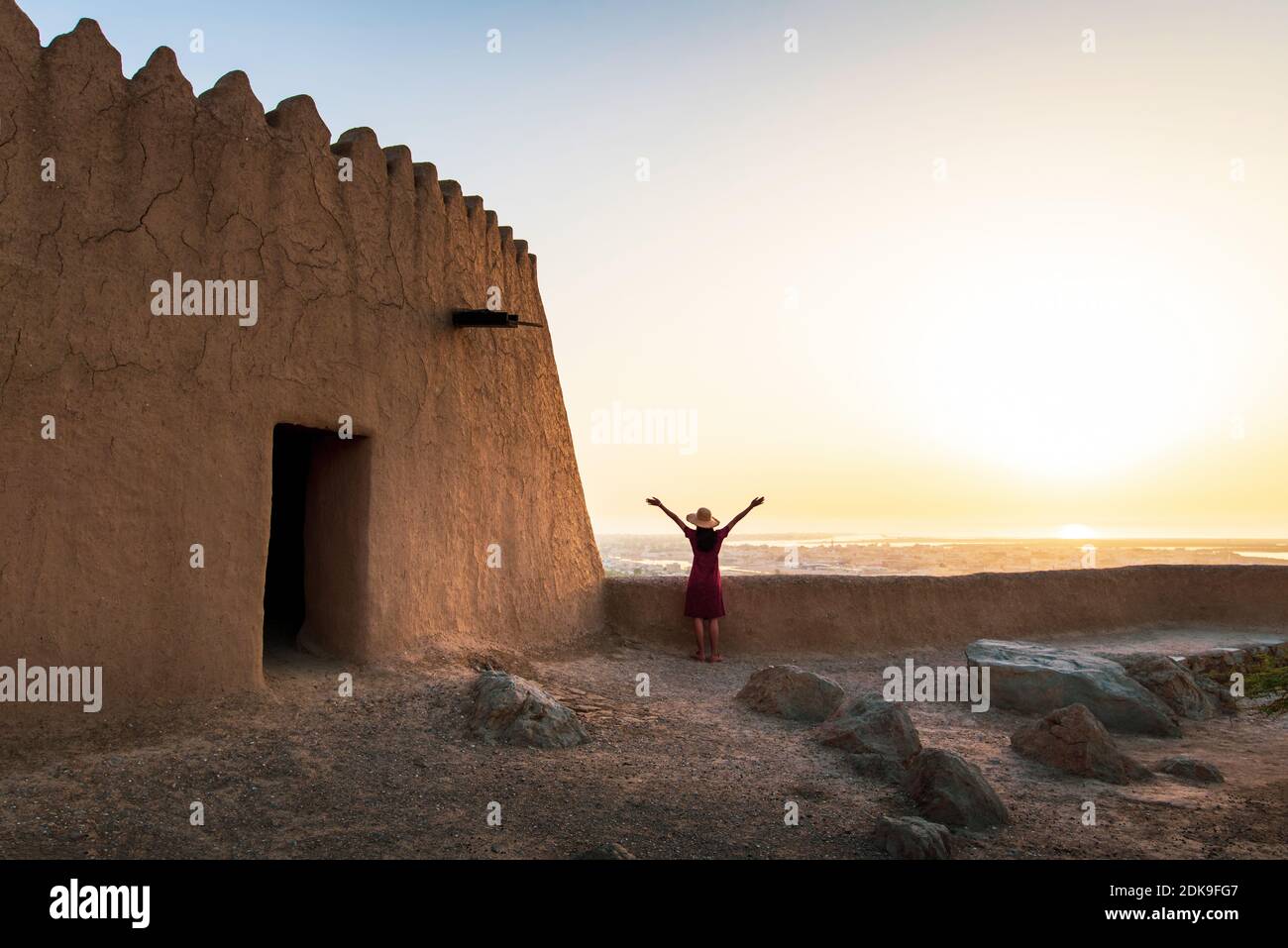 Voyageur féminin explorant le fort de Dhayah au nord de Ras Al Khaimah, aux Émirats arabes Unis, au coucher du soleil Banque D'Images