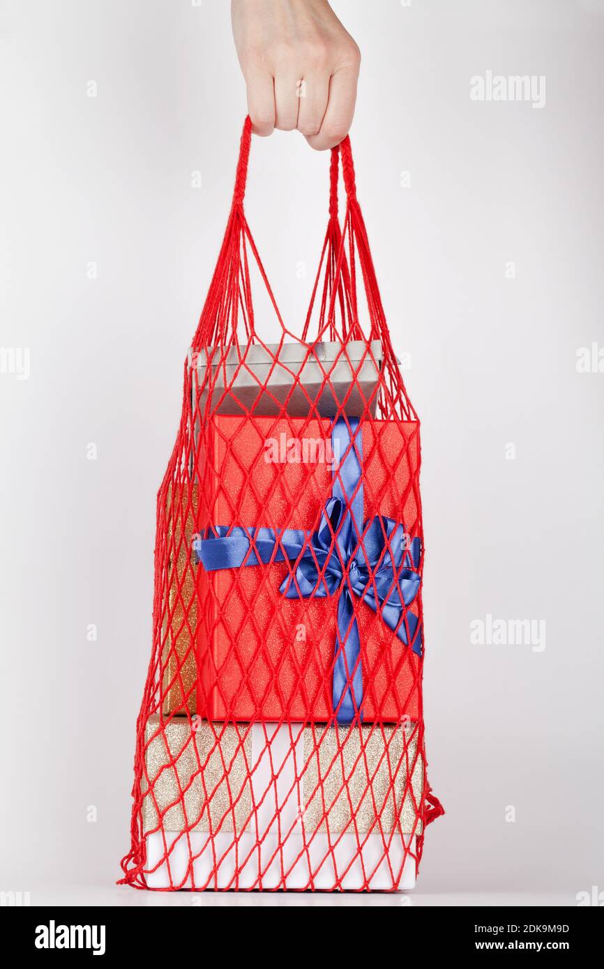 femme tenant à la main sac à provisions écologique réutilisable avec boîtes-cadeaux sur fond blanc. composition pour anniversaire, valentin, fête des mères, mariage. Banque D'Images femme tenant à la main sac à provisions écologique réutilisable avec boîtes-cadeaux sur fond blanc. composition pour anniversaire, valentin, fête des mères, mariage. Banque D'Images