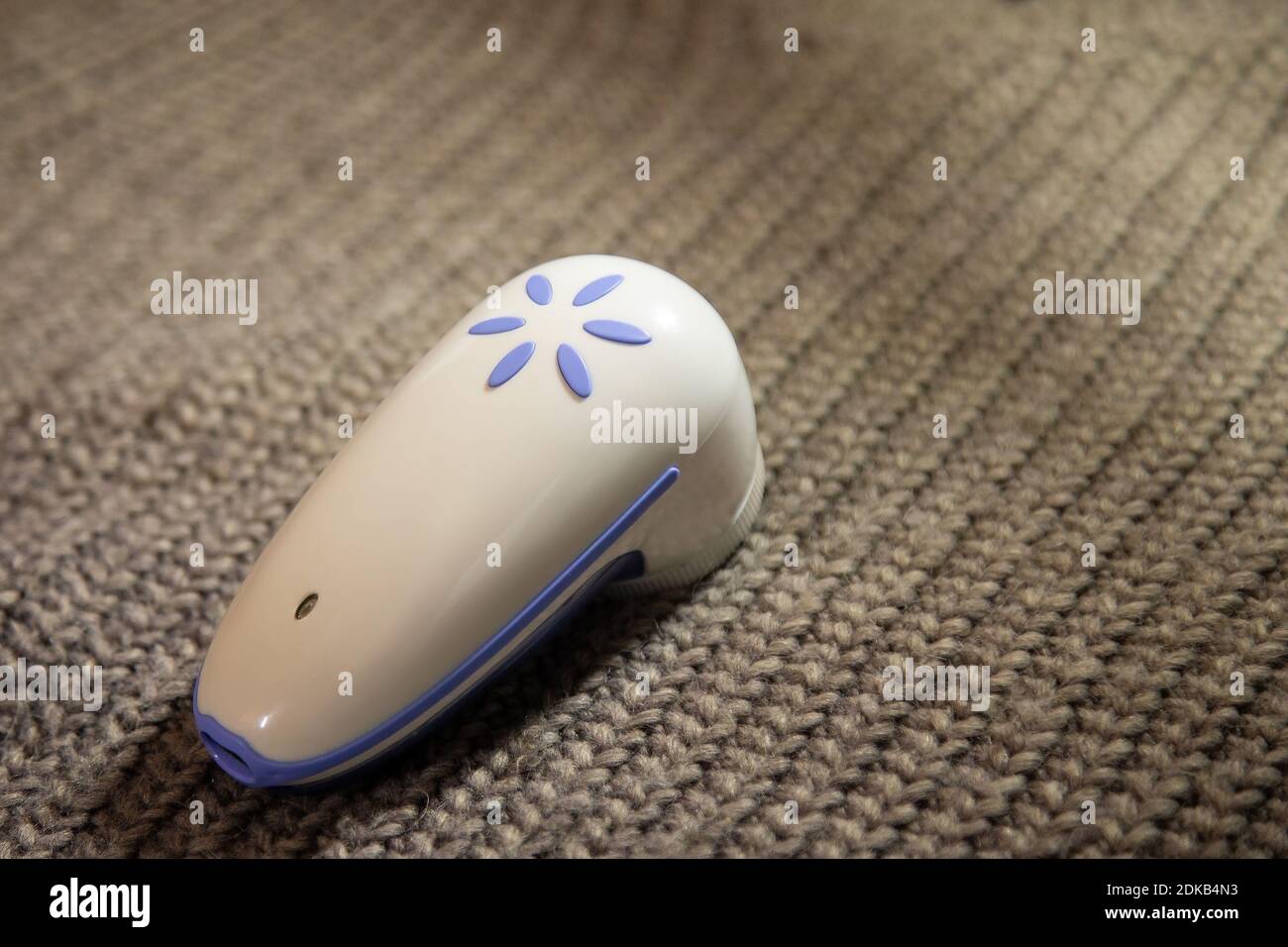 dispositif électrique pour enlever les cheveux et les peluches. Rasoir pour la laine. La machine pour enlever les granulés sur le fond d'un pull tricoté. Textile ca Banque D'Images