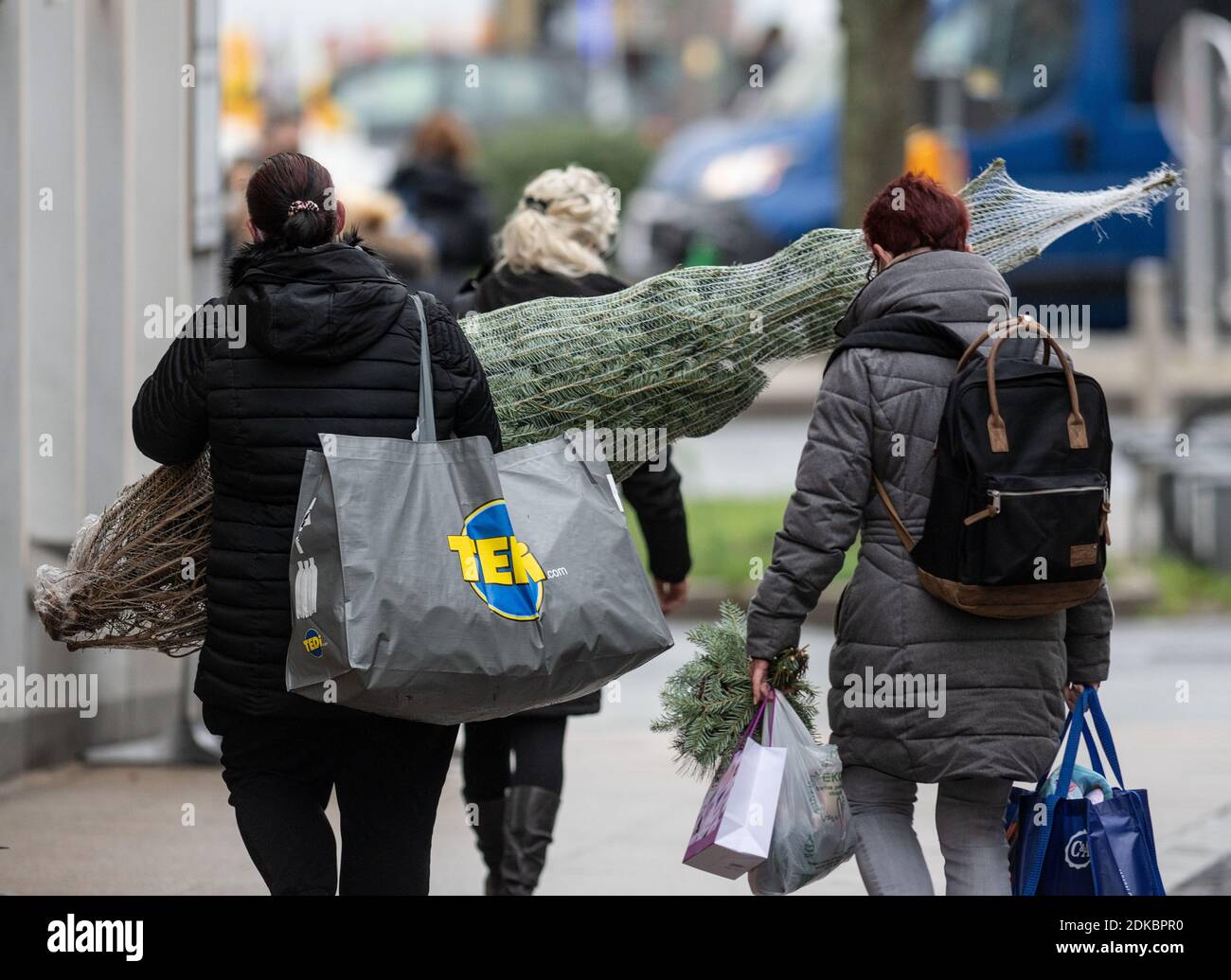 15 décembre 2020, Rhénanie-du-Nord-Westphalie, Dortmund : deux femmes marchent dans la zone piétonne avec leurs achats, y compris un arbre de Noël. A partir de demain, mercredi 16 décembre 2020 commence un verrouillage national, que les gouvernements fédéral et des États ont décidé. Photo: Bernd Thissen/dpa Banque D'Images