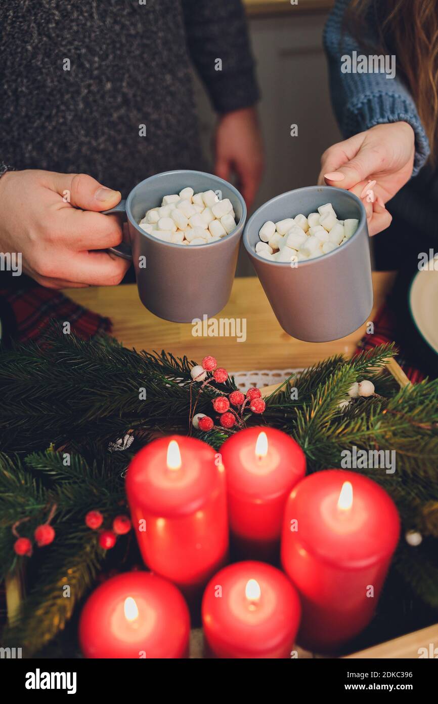 Homemade two Cocoa glasses with Marshmallows. Hot winter drink on wooden Backdrop decorated with cinamon sticks and fir branches Banque D'Images