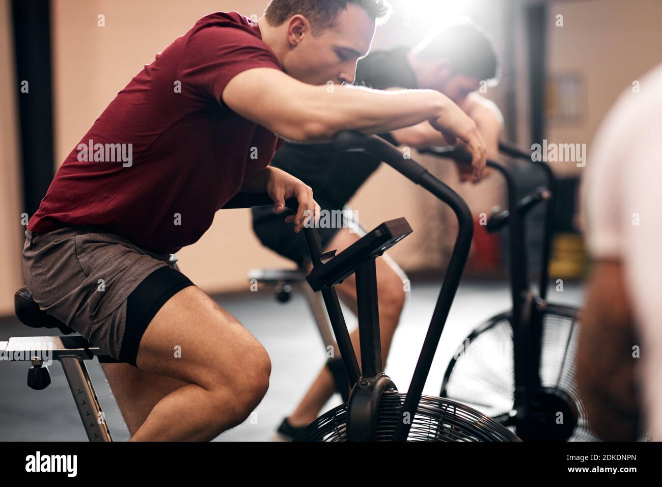 Faites des vêtements de sport pour les jeunes hommes qui ont l'air épuisés après un entraînement cours sur les vélos d'appartement à la salle de gym Banque D'Images