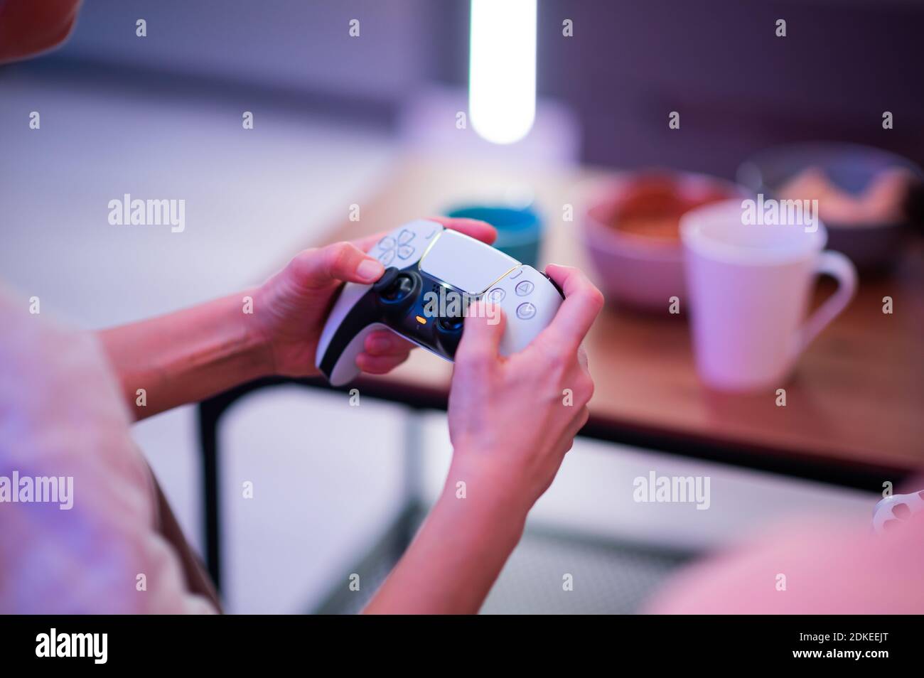 Fille utilisant la nouvelle manette sans fil DualSense PlayStation 5 de Sony qui offre un retour haptique immersif, des déclencheurs dynamiques adaptatifs et un intégré Banque D'Images