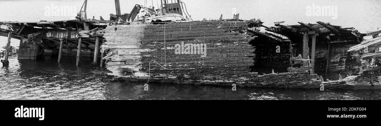 Fragment de navire pourri, abandonné sur la rive, symbole de décadence et de dégradation, image monochrome Banque D'Images