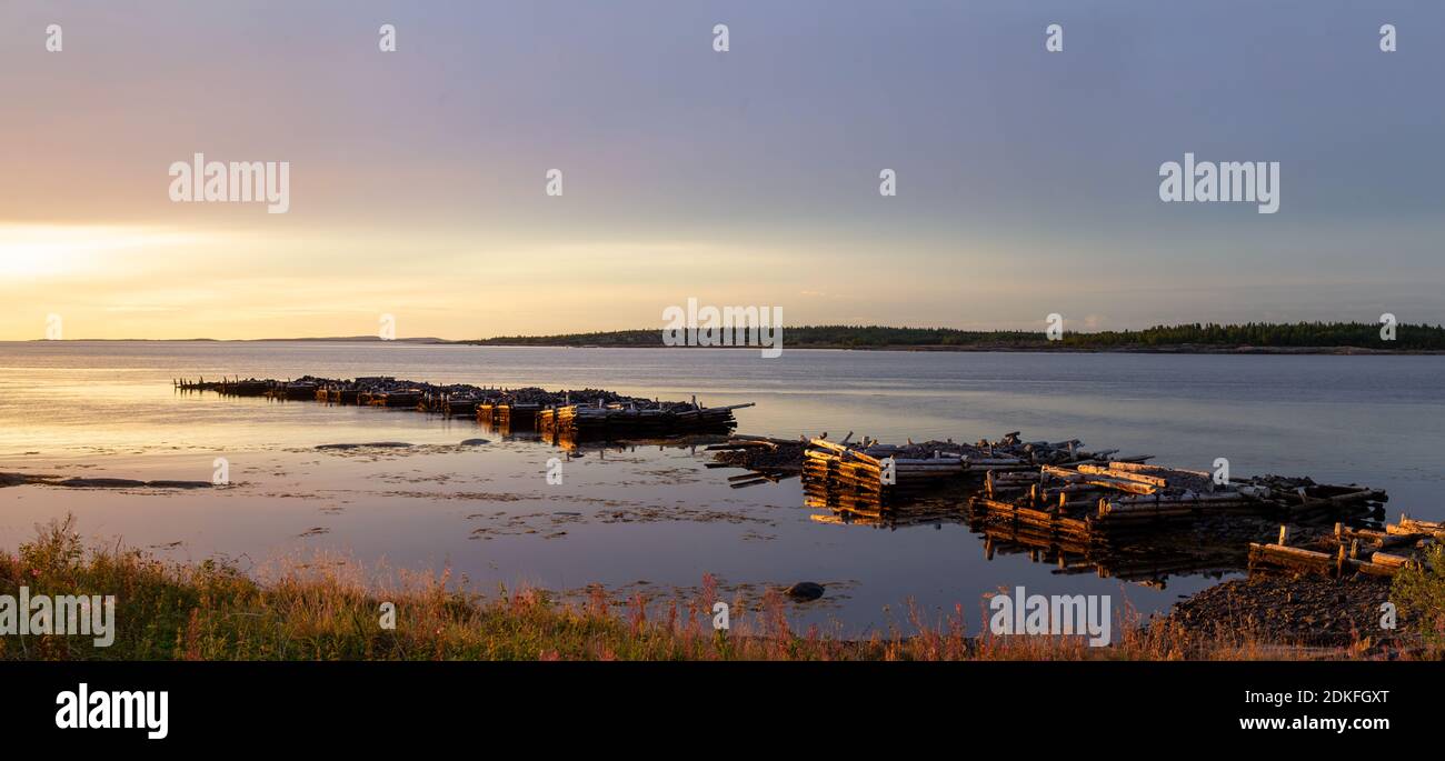 Vieux quai en ruines dans la mer en début de matinée sur un lever de soleil coloré au-dessus de la mer Blanche, Russie Banque D'Images