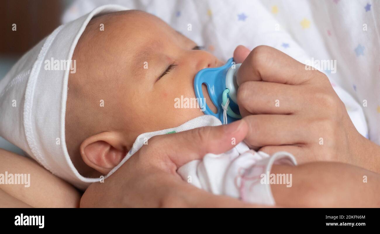 Mere Chaude Tenir Asiatique Joli Bebe Nouveau Ne Bebe Garcon Dormir Apaisement Avec La Sucette Photo Stock Alamy