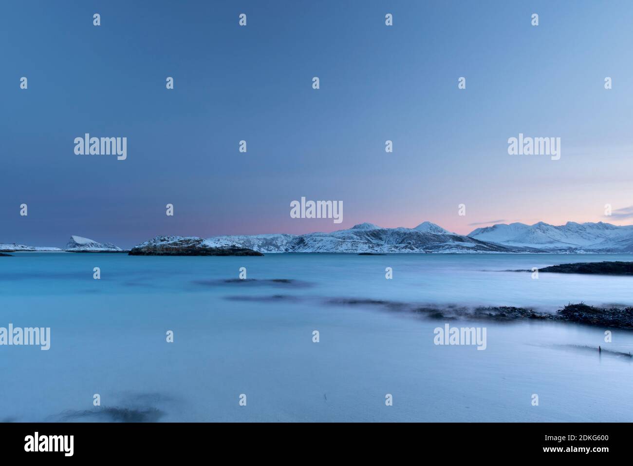 Aube givrée sur l'île de Sommaroy en hiver avec vue De la plage de la mer d'Europe du Nord et de la montagnes enneigées à l'horizon Banque D'Images