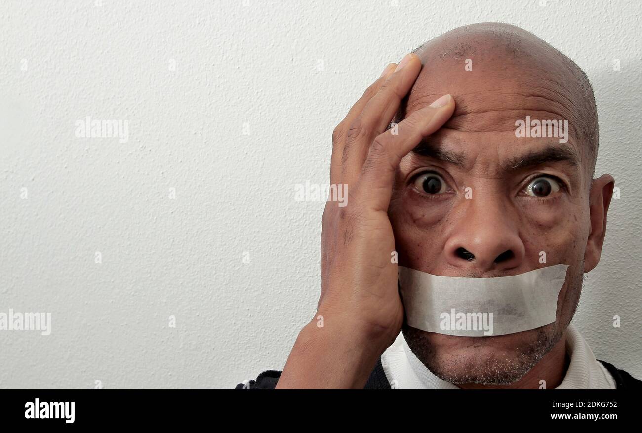 les hommes ressentent la douleur après avoir été discriminés avec la bande sa bouche sur fond blanc photo Banque D'Images